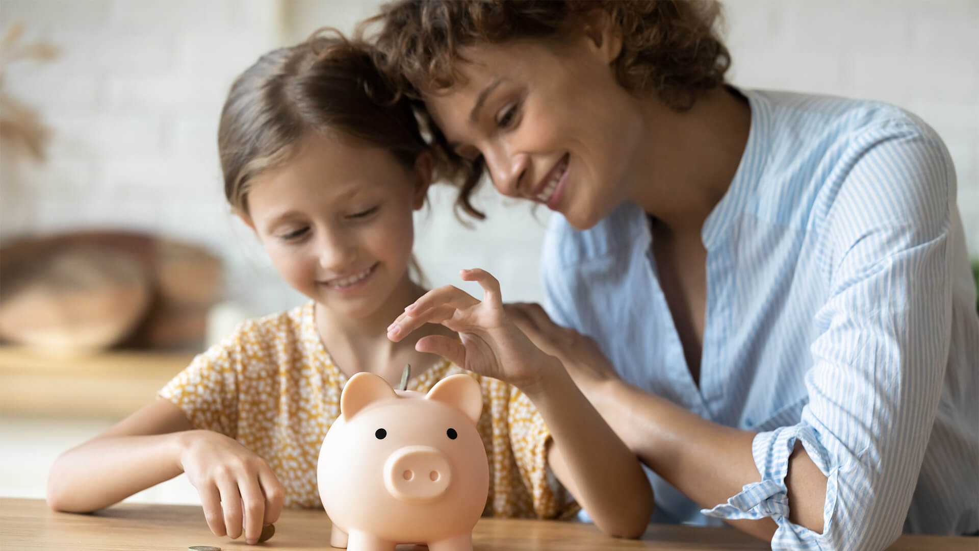 mother teaching small preschool kid daughter saving money or planning future purchases