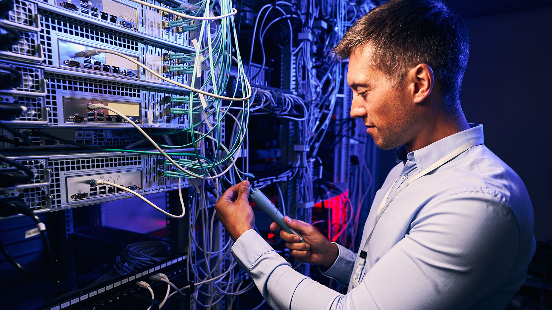 Focused data center employee checking cabling infrastructure