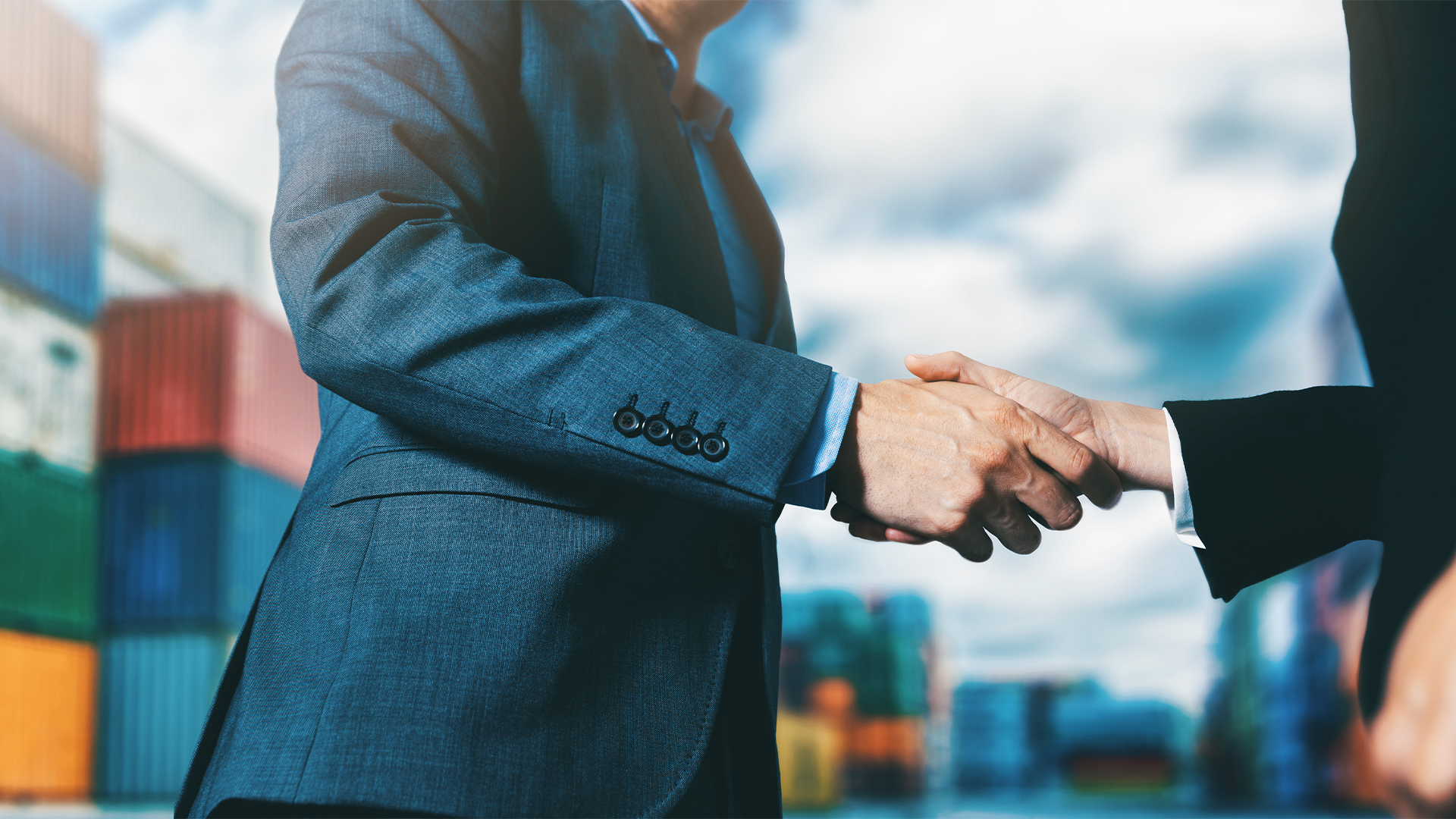 export and import business. businessmen handshake at industrial container terminal.