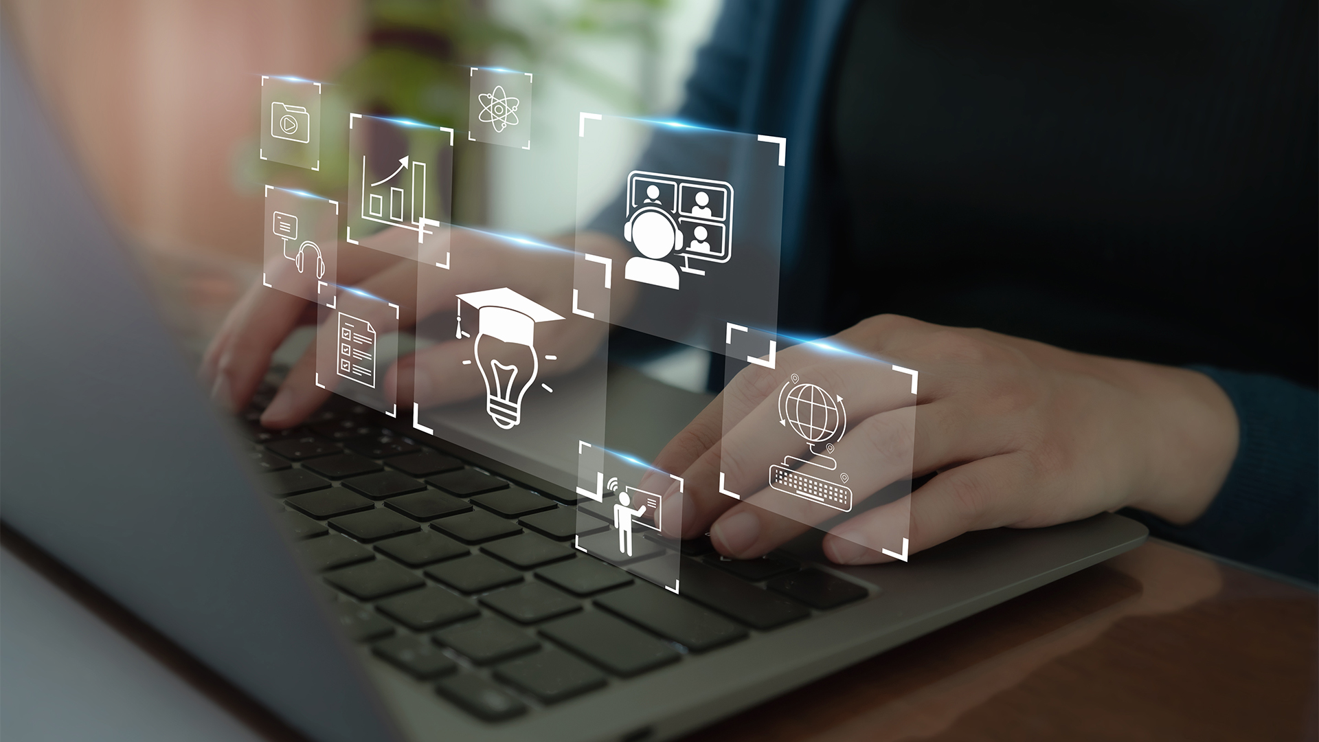 hands typing on laptop with icons floating around
