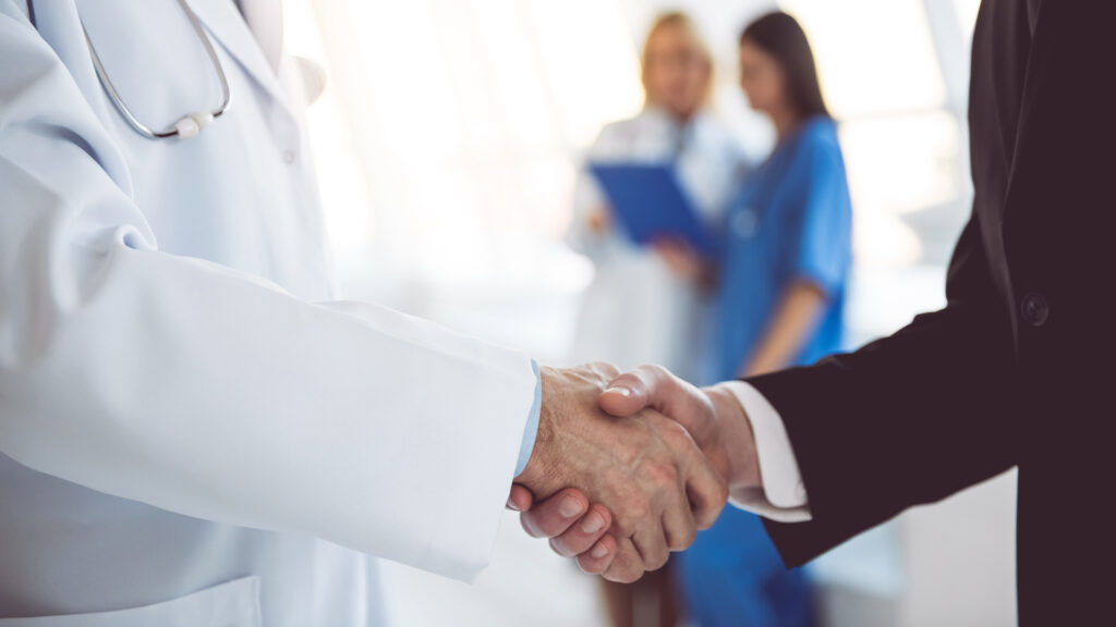 Doctor and businessman shaking hands