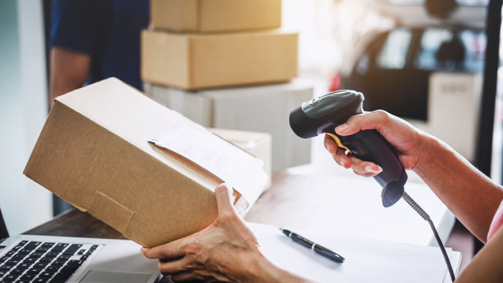 Woman working barcode scan to confirm sending customer in post office