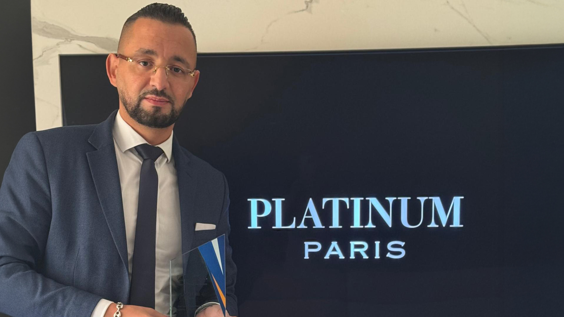 Man in suit holding trophy